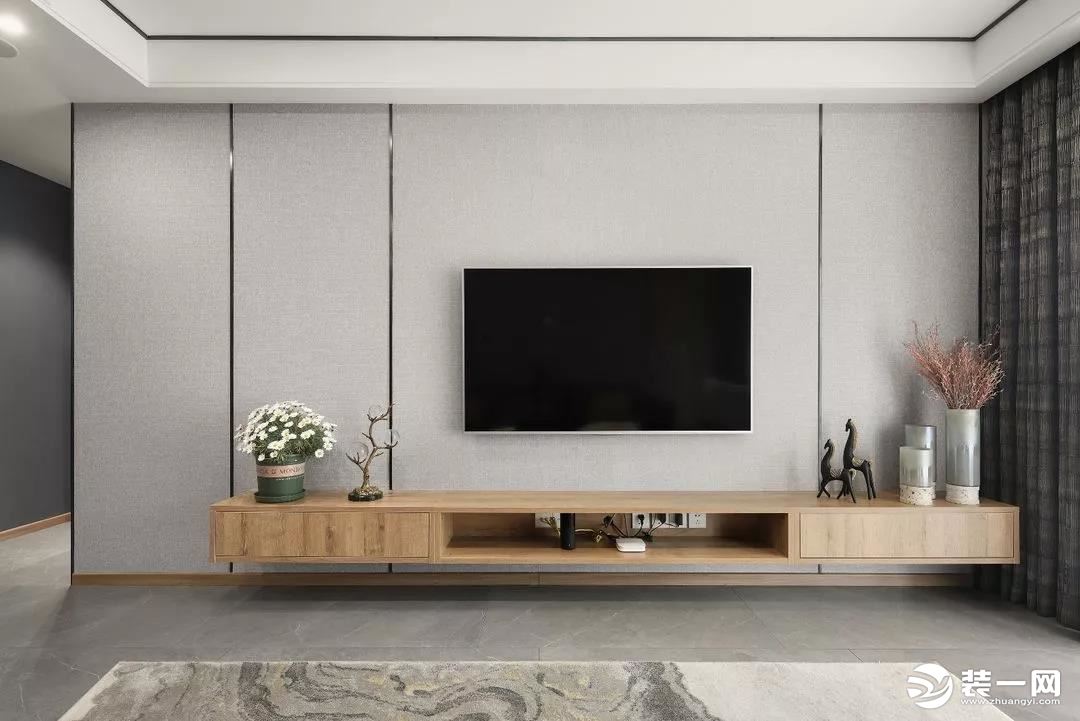 电视背景墙用灰色墙布和线条划分,电视柜中部留空,内藏插座,方便日常